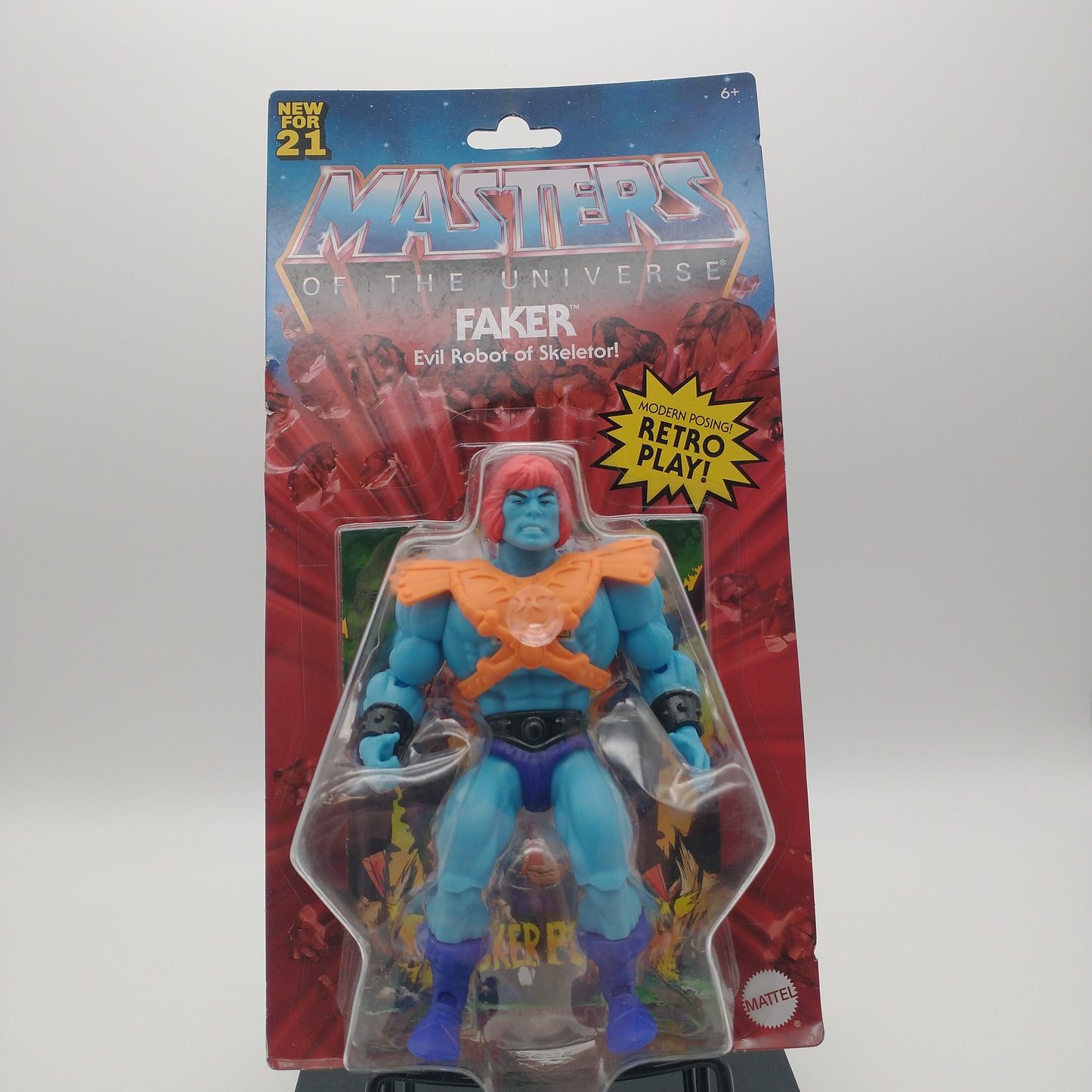 The front of the box and bubble. The bubble is sealed, the action figure inside is a blue man with red hair. He's wearing an orange chestplate and a dark blue speedo.