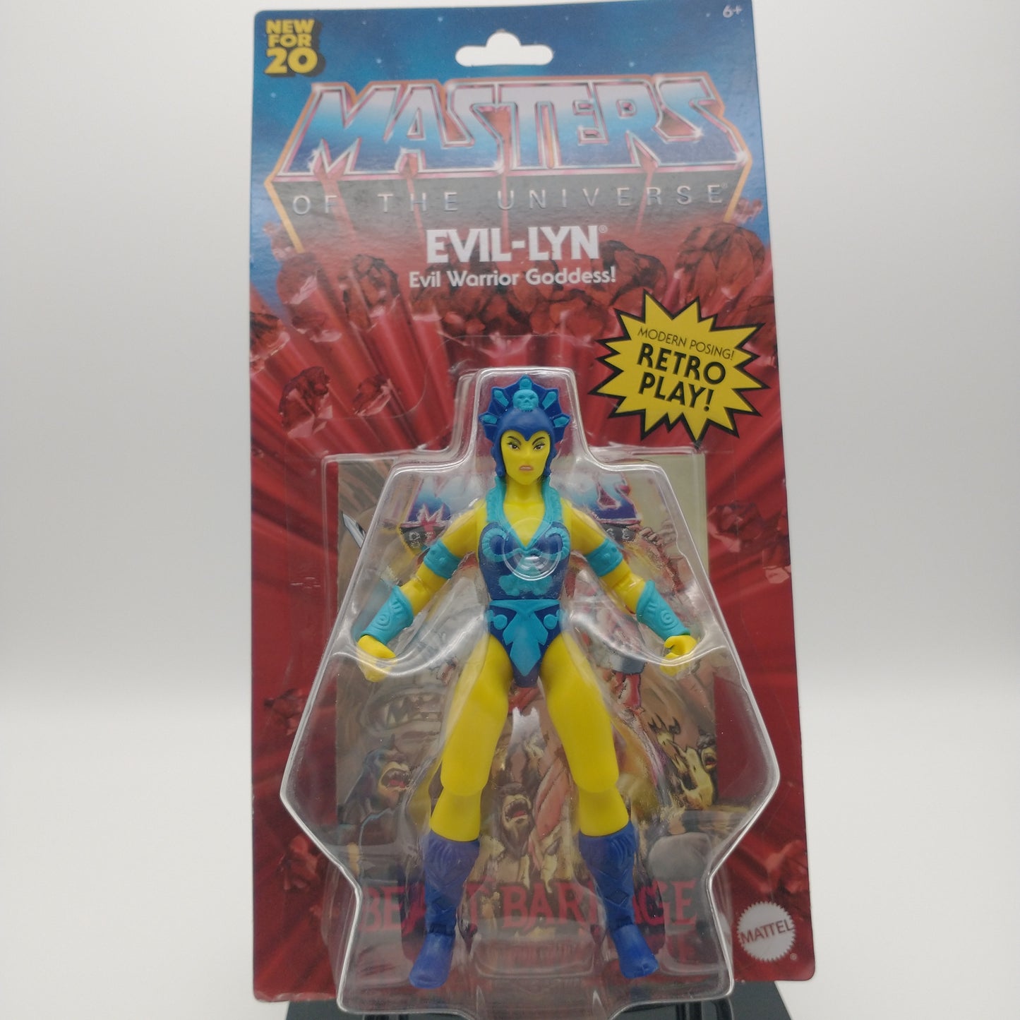 The front of the box and bubble. The bubble is sealed, the action figure inside is a woman with yellow skin, a dark blue leotard with light blue highlights, a blue head dress, dark blue boots, and light blue arm bands. 