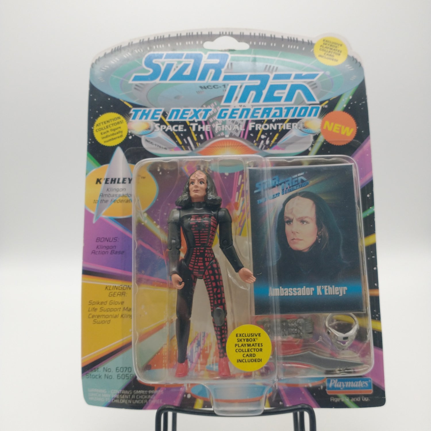The front of the box and bubble. The bubble is sealed, the action figure inside is wearing a black skin-tight suit she has black hair and red scales up the side of the leg.