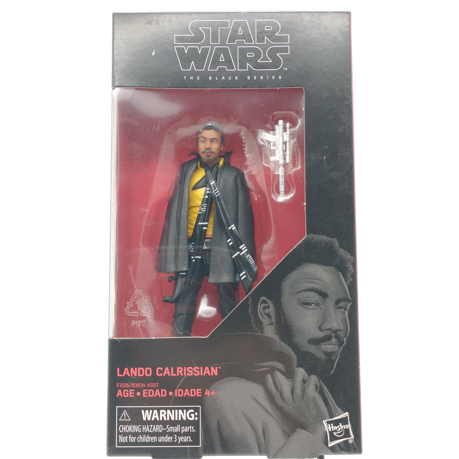 The front of the box and bubble are intact. The action figure inside the box is dark skinned with black hair. He is wearing a black shoulder cape and a yellow shirt. Next to him in the bubble is a white gun