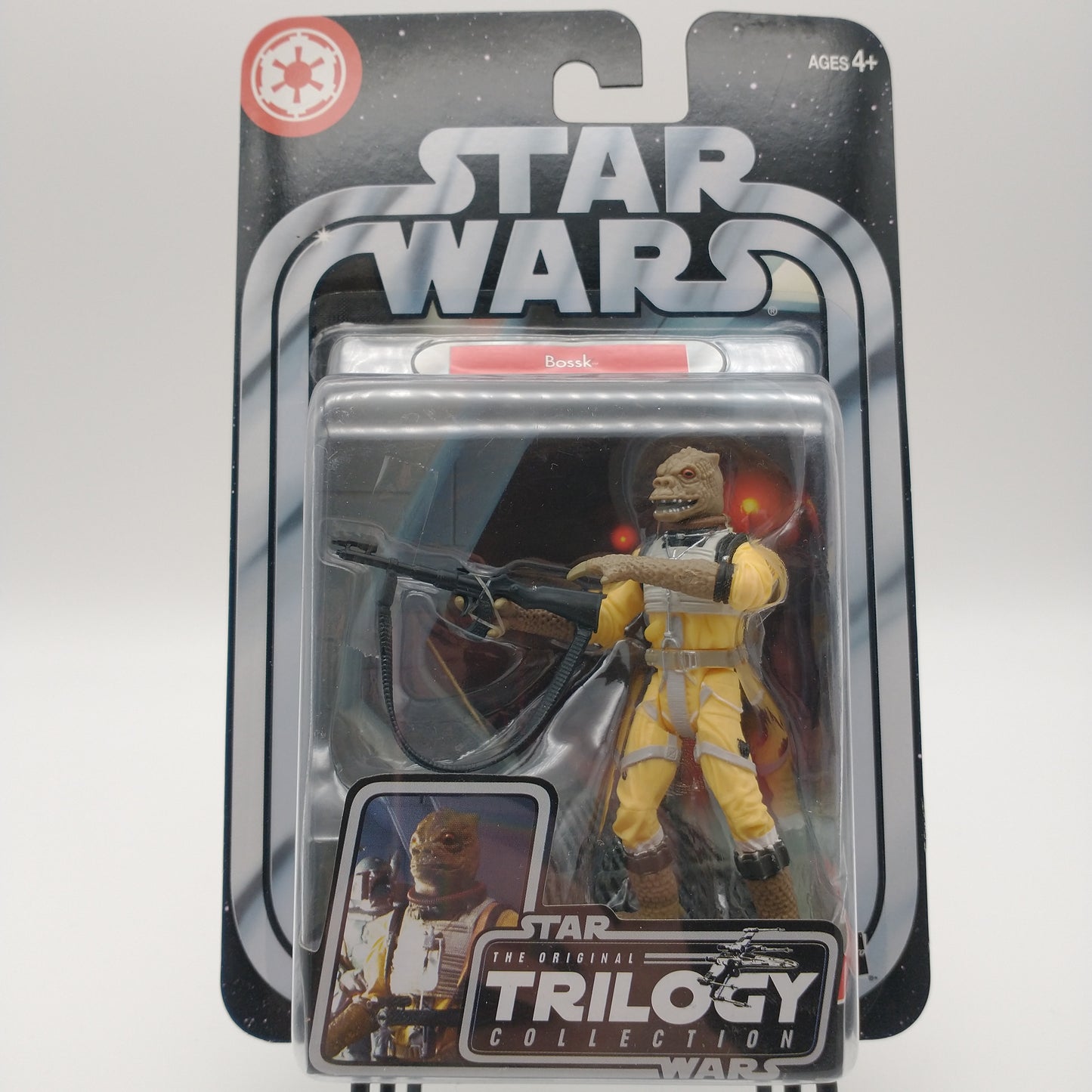 The front of the cart and bubble are intact. The action figure inside is a lizard humanoid wearing a yellow jumpsuit, and holding a large gun.