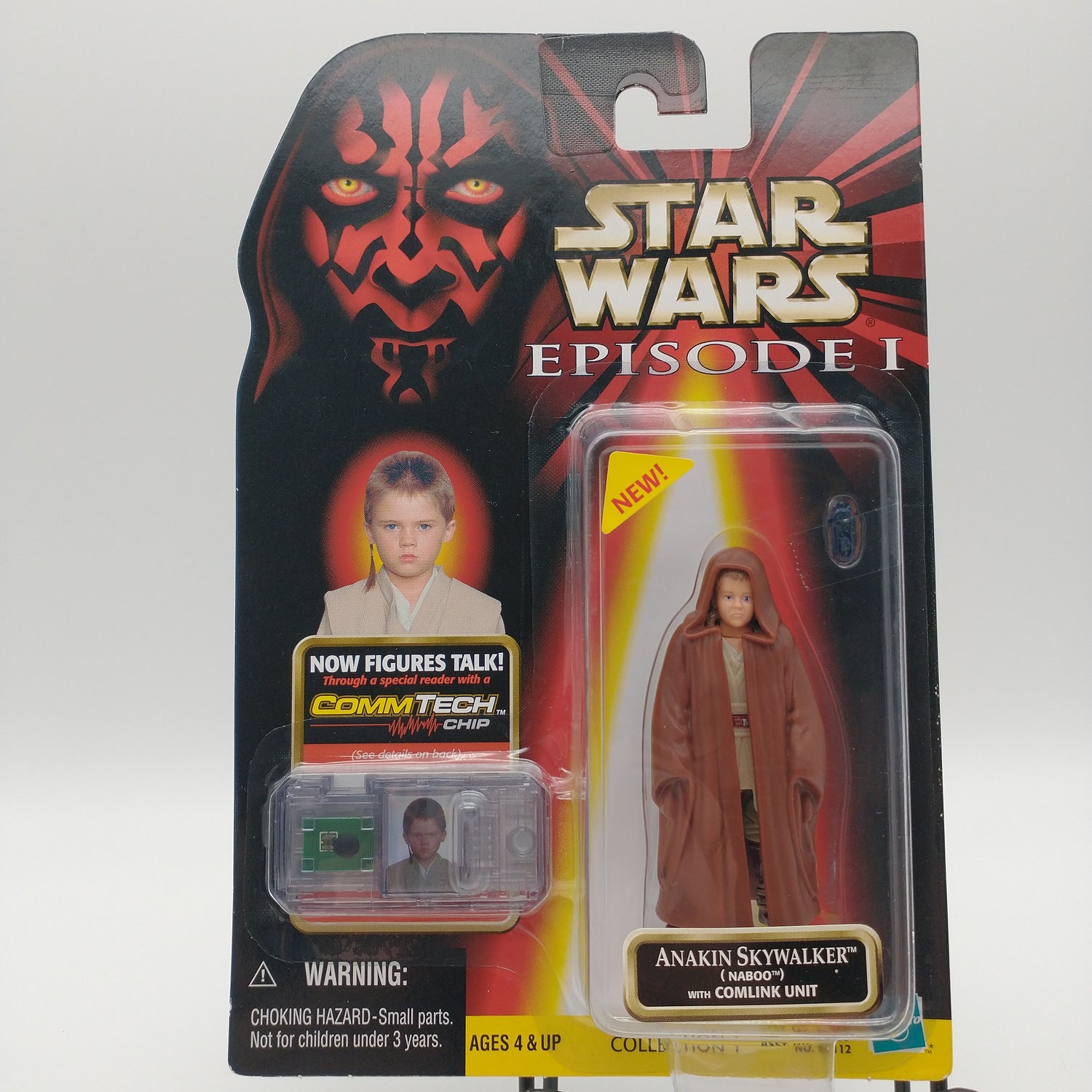 The front of the card and bubble is intact. The action figure inside is a small child wearing long brown robes. Next to him in a seperate bubble is the commtech chip.