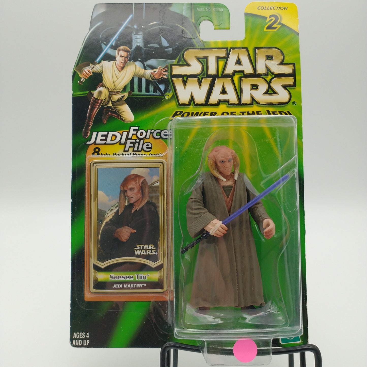 The front of the card and bubble are in good condition and intact. The action figure is a humanoid alien with downward curving tusks and long brown robes. He's holding a blue lightsaber