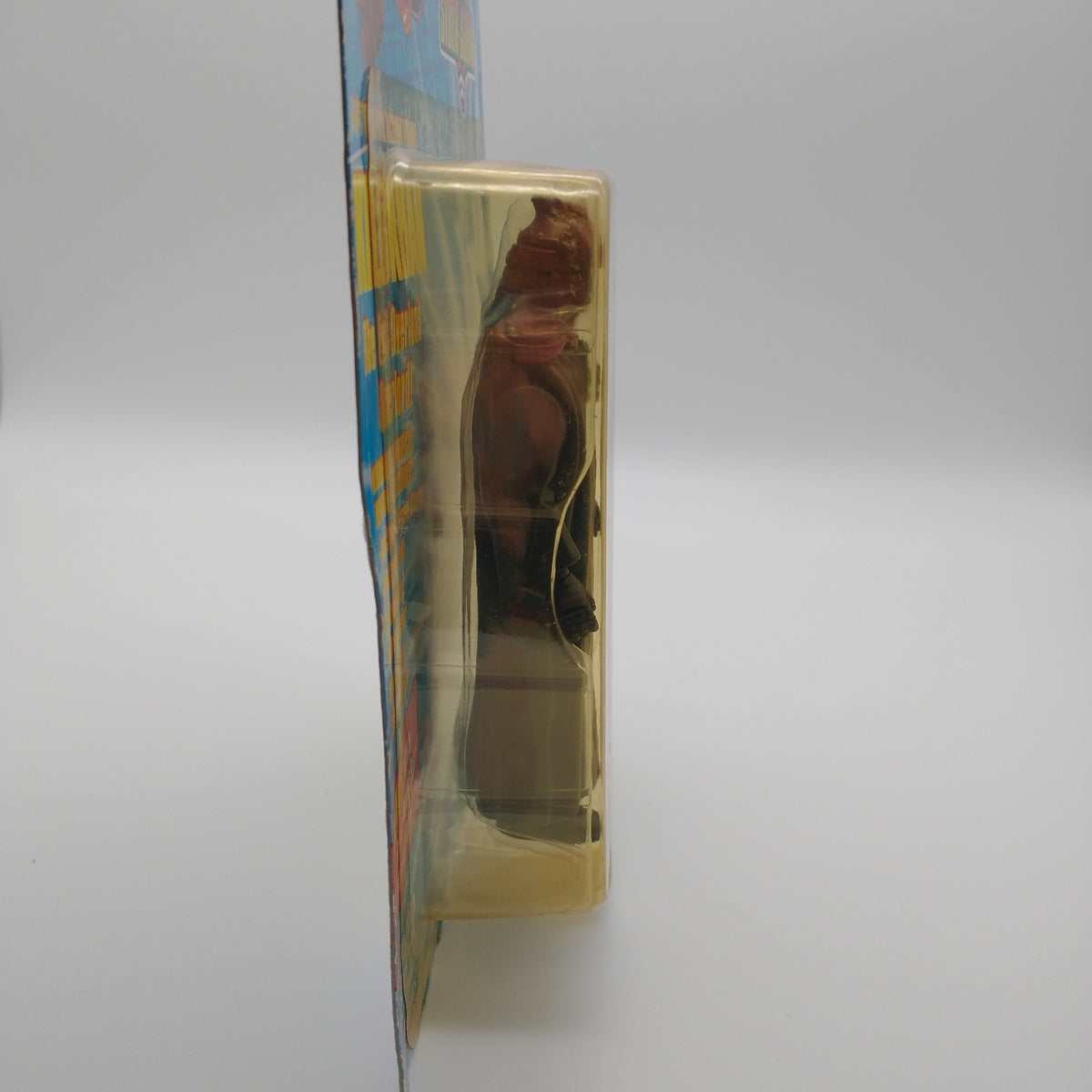 A picture of the bubble from the side. The bubble is slightly yellowed, the action figure of klokhan is visible from the side. 